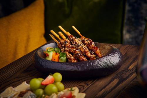 a bowl of food on a wooden table with fruit at Hotel Gorinchem in Gorinchem