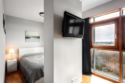 a bedroom with a bed and a tv on a wall at Vorto Apartament 3 - Warszawa Centrum in Warsaw