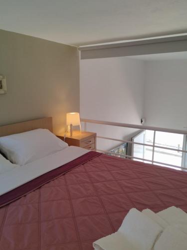a bedroom with a bed with a red blanket at Spata center loft in Spata