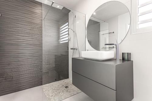 een badkamer met een wastafel en een spiegel bij Villa GREEN in Saint-François