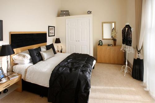 a bedroom with a bed and a desk with a mirror at Pew Corner at Chapel Collection in Cinderford