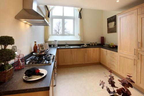 a kitchen with a stove and a sink in it at Pew Corner at Chapel Collection in Cinderford