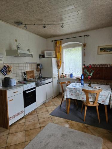 a kitchen with a table and a kitchen with white appliances at Ferienwohnung am Wald in Tharandt