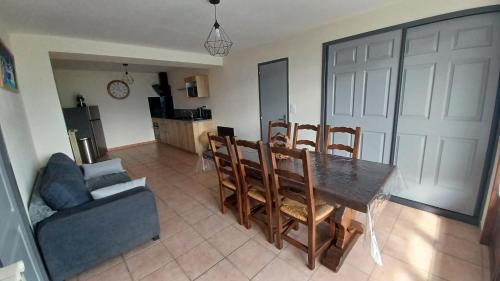 un salon avec une table, des chaises et un canapé dans l'établissement Le puny, à La Motte-en-Champsaur