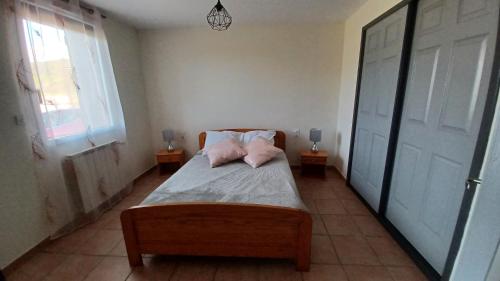 una camera con un letto con due cuscini sopra di Le puny a La Motte-en-Champsaur