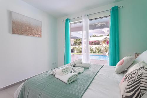 1 dormitorio con 1 cama con toallas en Villa GREEN en Saint-François