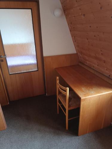 a room with a wooden desk and a window at Penzion Hana in Hracholusky