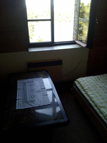 a room with a window and a table with a book on it at Penzion Hana in Hracholusky