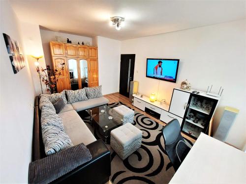 a living room with a couch and a tv at 3 Rooms Apartment, Top Center, 1st Floor, AUBG, WiFi, PC i5 SSD, Tablet, AndroidMiTvBox, 3 LED TVs 200 Channels, Long Terrace, Self-Easy-Late Check-in, Stay Before Greece in Blagoevgrad
