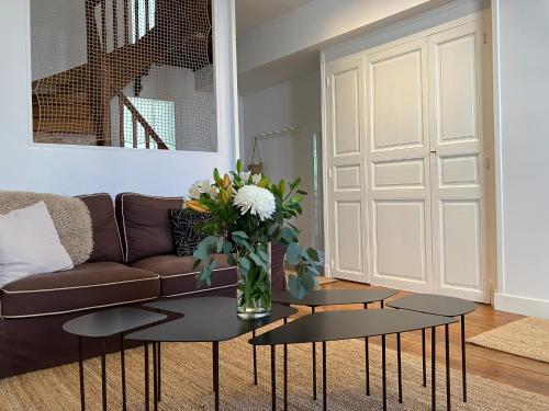 - un salon avec un canapé et un vase de fleurs sur une table dans l'établissement La Petite Maison du 9, à Saint-Aignan