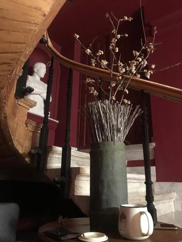 a vase with flowers in it sitting on a table at VASILIKON Hotel 1888 the past is present HISTORICAL PRESERVATION MONUMENT in Kalamata