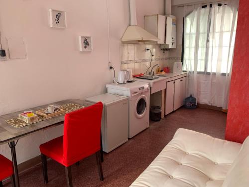 cocina con lavadora y silla roja en Cassanova II en San Luis