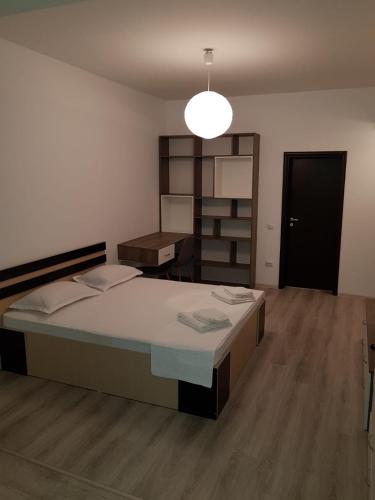 a bedroom with a large bed and a desk at CONFORT' by J in Iaşi