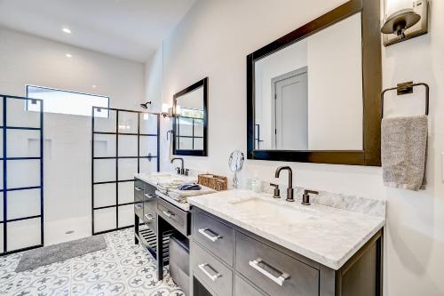 a bathroom with two sinks and a large mirror at Serene Austin Stunner in Austin