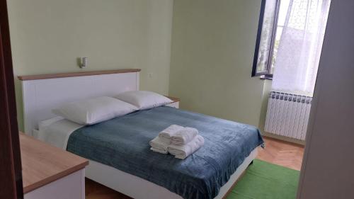 a bedroom with a bed with two towels on it at Iva in Zadar