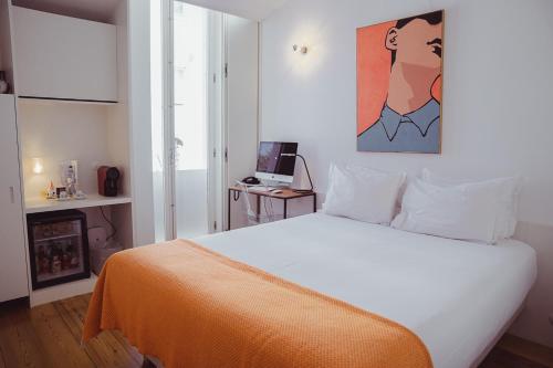 a bedroom with a white bed with an orange blanket at The Late Birds Lisbon - Gay Urban Resort in Lisbon