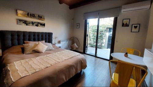查克拉斯德科里亞的住宿－Moderno departamento para dos personas en Chacras de Coria，一间卧室配有一张大床和一张桌椅