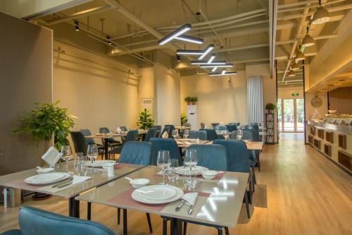 a dining room with tables and blue chairs at Gubei Water Town Landscape Villa in Miyun