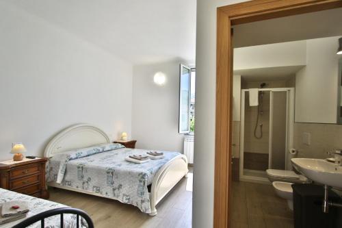 um quarto com uma cama e uma casa de banho com um lavatório em Appartamento sole&mare em Levanto