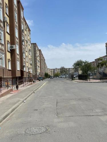 eine leere Straße in einer Stadt mit hohen Gebäuden in der Unterkunft Апартаменты у Натальи in Aqtau