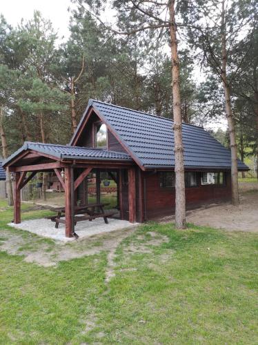 a pavilion with a picnic table in a park at Dom Nad Stawem Krawno in Piecki