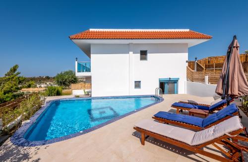 a villa with a swimming pool and patio furniture at Kolymbia Village in Kolimbia