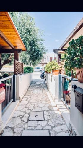 a stone walkway with a fence and some plants at Appartamento BluOltreMare in San Vito lo Capo