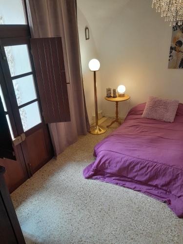 a bedroom with a purple bed and a window at Da Julia in Oristano