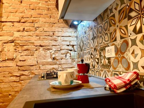 uma cozinha com uma parede de tijolos e uma bancada em Old town Chioggia apartments em Chioggia