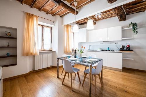 een keuken en eetkamer met een tafel en stoelen bij SUITE 35 Collection - Soggiorna con stile nel Cuore di Siena in Siena