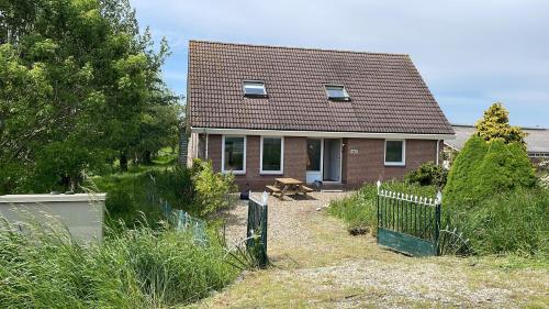 a small house with a fence in front of it at Guesthouse at the Amstel river with 2BR 2BA and garden in Amstelveen