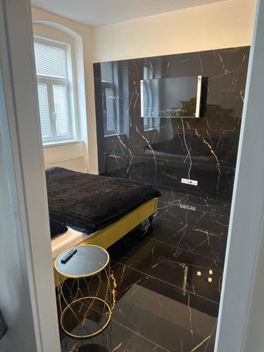 a bedroom with a bed and a black marble floor at Luxuriöse Wohnung Appartement im direkten Zentrum von Karlsbad in Karlovy Vary