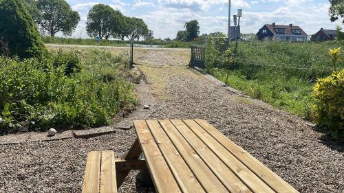 a wooden bench sitting on the side of a dirt road at Guesthouse at the Amstel river with 2BR 2BA and garden in Amstelveen