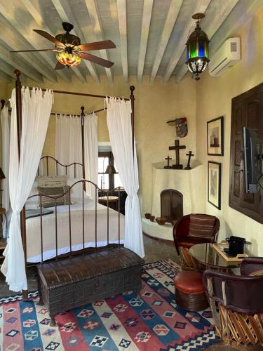 a bedroom with a bed with a fan and a fireplace at Hacienda Las Amantes in San Miguel de Allende