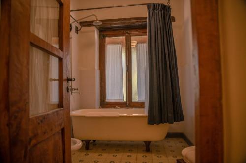 baño con bañera y ventana en Posada Rural La Matilde en San Javier