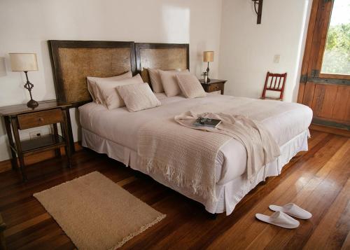 a bedroom with a large bed with a pair of shoes at Posada Rural La Matilde in San Javier