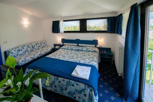 a bedroom with two beds and a window at Bike Hotel Villa Maria in Nago-Torbole