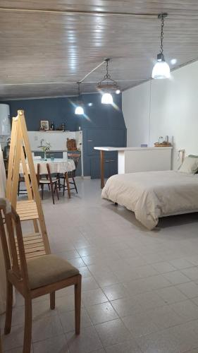 1 dormitorio con 1 cama, 1 silla y 1 mesa en Monoambiente pequeño en Carmen de Patagones