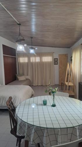 Zimmer mit einem Tisch und einem Bett sowie einem Schlafzimmer in der Unterkunft Monoambiente pequeño in Carmen de Patagones