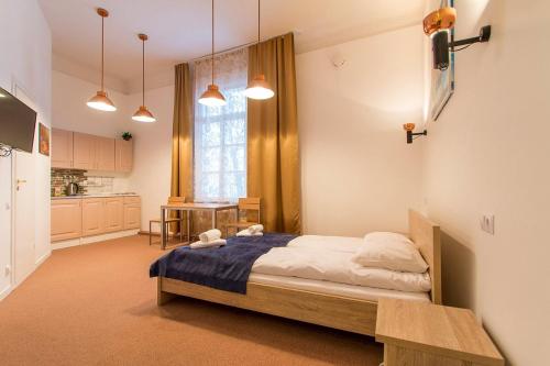 a bedroom with a large bed and a kitchen at Aquamarine Hotel - Lauluväljak in Tallinn