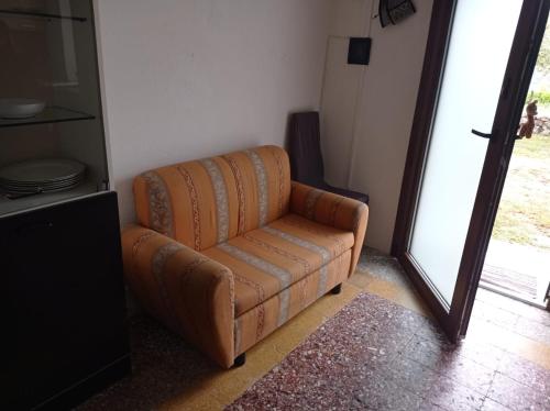 a brown couch in a living room with a mirror at Su Cuile historical country house with barbecue in Martis
