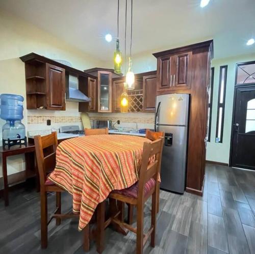 a kitchen with a table with chairs and a refrigerator at Apartamento Jacob in San Pedro La Laguna