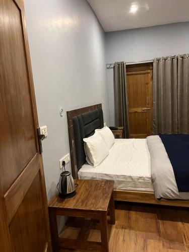 a small bedroom with a bed and a table at Honey Bee in Leh