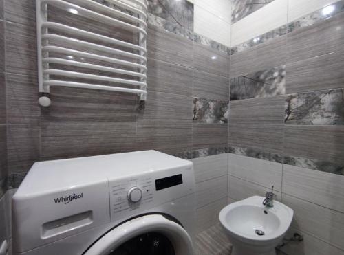 La salle de bains est pourvue d'un lave-linge et d'un lavabo. dans l'établissement 2-х кімн квартира в новобудові, à Ternopil