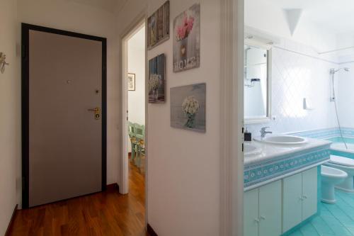 a bathroom with a sink and a toilet and a mirror at Attico Centralissimo Vista Mare in Torvaianica