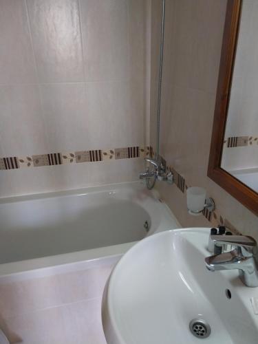 a bathroom with a sink and a bath tub at Piringolf apartment in Razlog