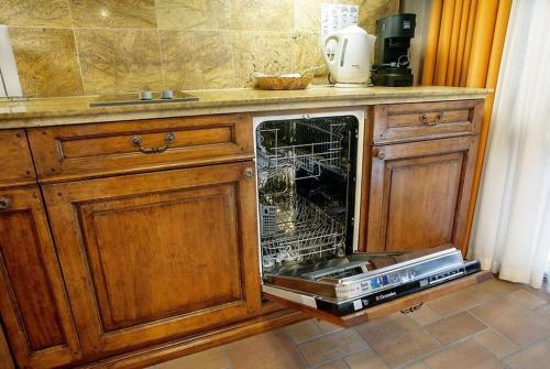 a dishwasher with its door open in a kitchen at Jaukūs Friedricho pasažo apartamentai in Klaipėda
