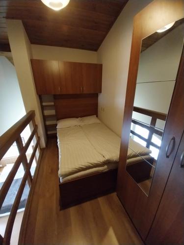 a small room with a bed and a mirror at Piringolf apartment in Razlog