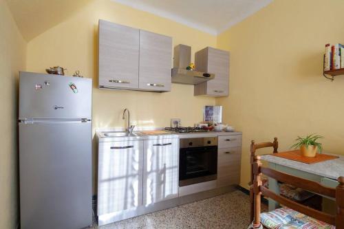 a kitchen with a white refrigerator and a table at DaFramanco2 Country house close to 5 Terre in Quaratica