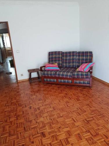 un sofá en una habitación con suelo de madera en Profiter,de,la,mer,et,de,Lisbonne,, en Alcabideche